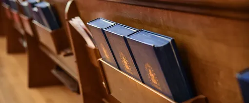 hymnals in the back of a pew